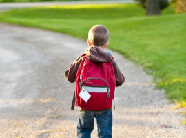  child walking with red backpack